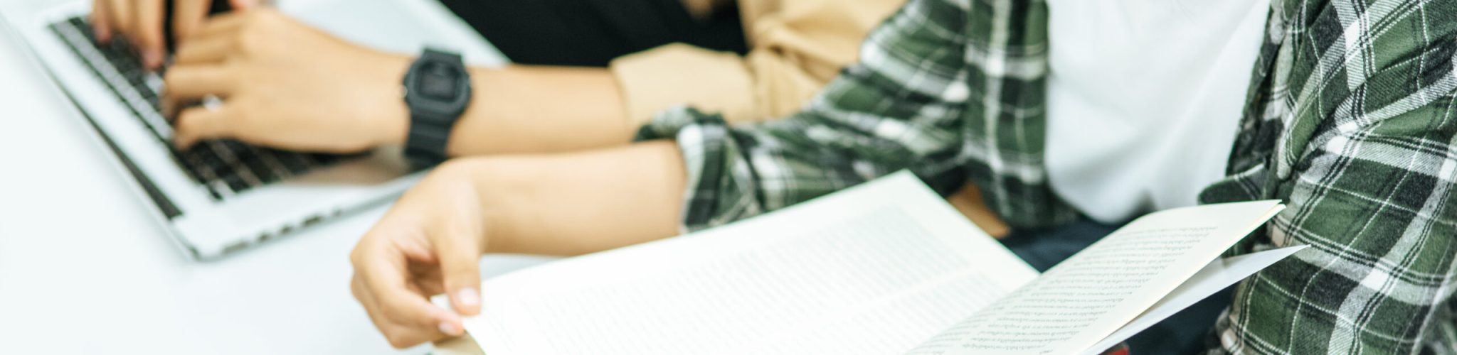 Women read books and men use laptops to search for books in libraries.